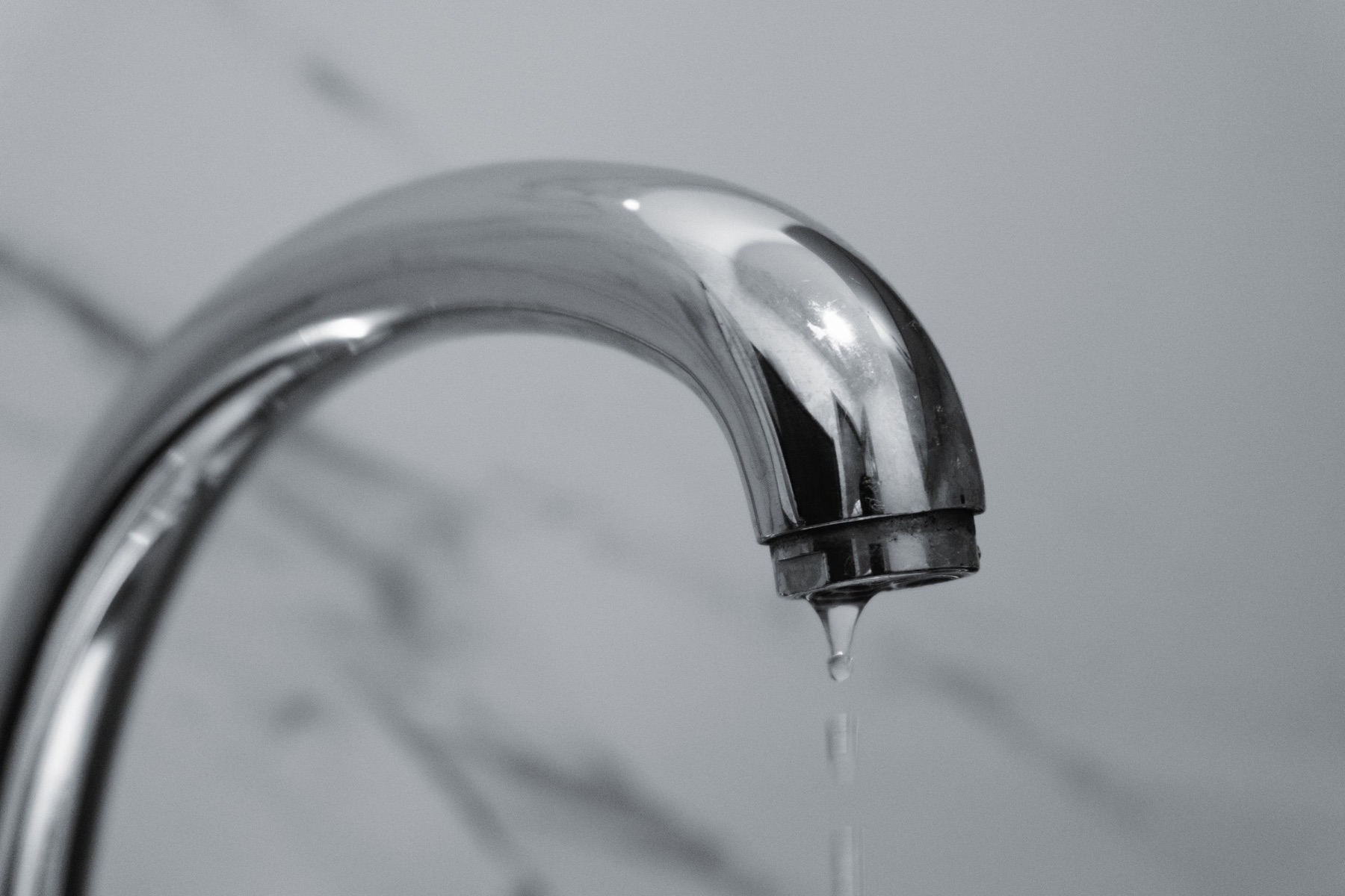 A faucet dripping over a bathroom sink